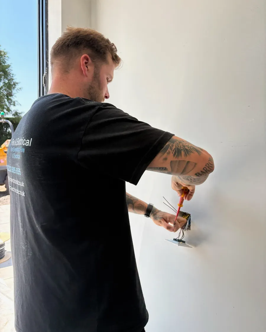 TJC electrician working at a wall point