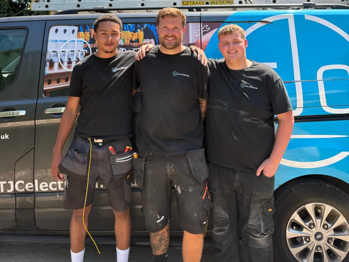 Three TJC electricians standing in front of a TJC-branded van