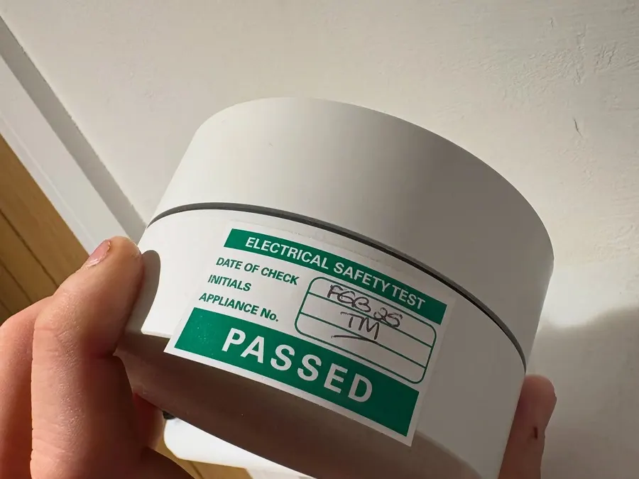 Emergency light fitting carrying a green passed electrical safety test label
