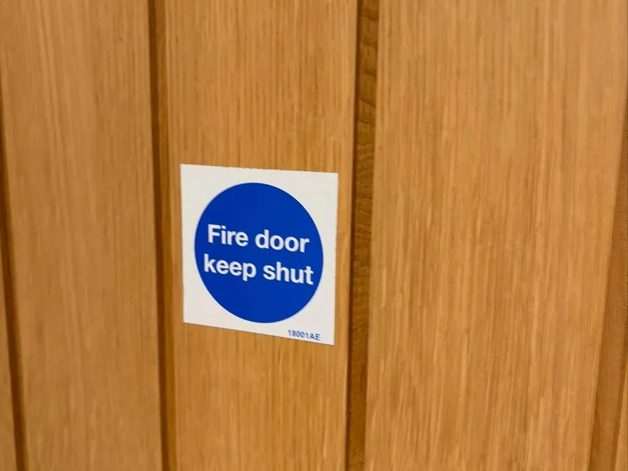 Fire door keep shut sign on an oak door