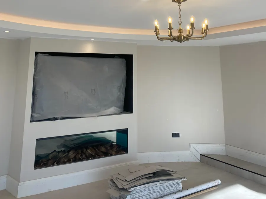 Living room with a brass chandelier in a cove-lit recessed ceiling