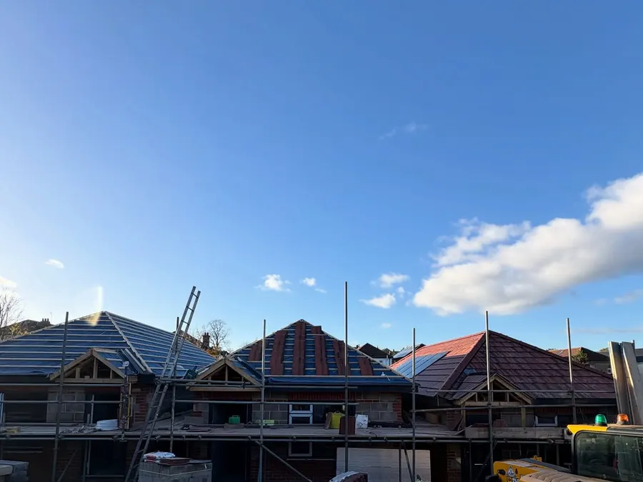 Three bungalow plots in scaffolding with roofs being tiled