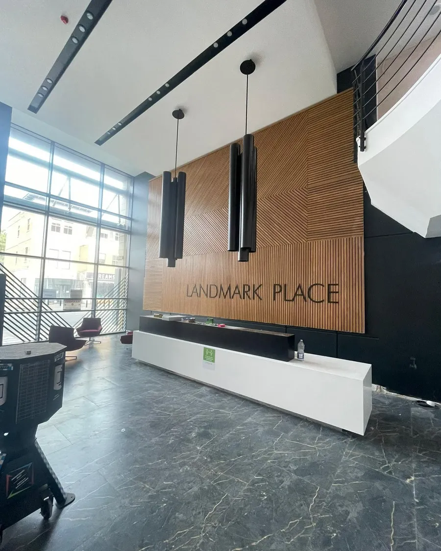 Apartment building reception with a branded timber feature wall and pendant lighting
